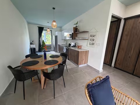 Dining area with round table and kitchen in background